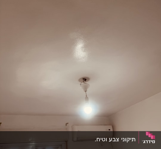מנורה תלויה ותקרת חדר עם מזגן
